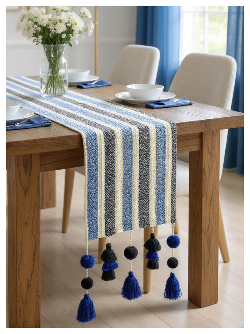 Dining table with a striped blue and white table runner and tassels.