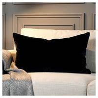 Black velvet lumbar pillow styled on a light coloured sofa