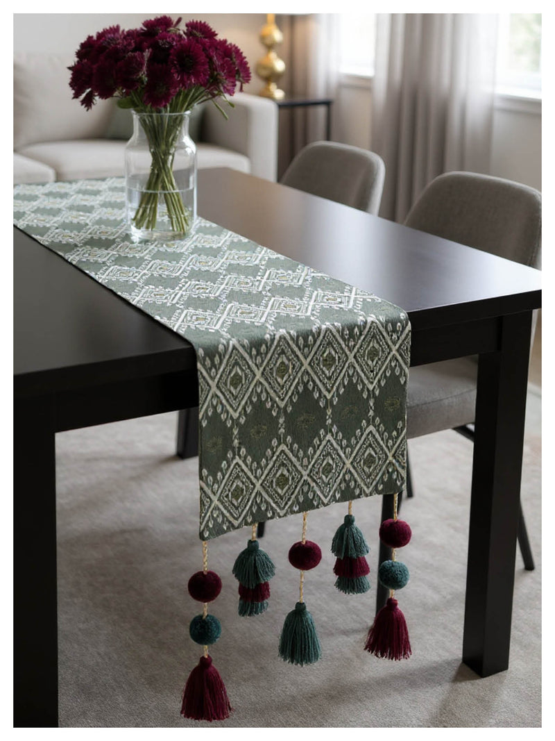 Decorative table runner with tassels on a dining table in a home setting.