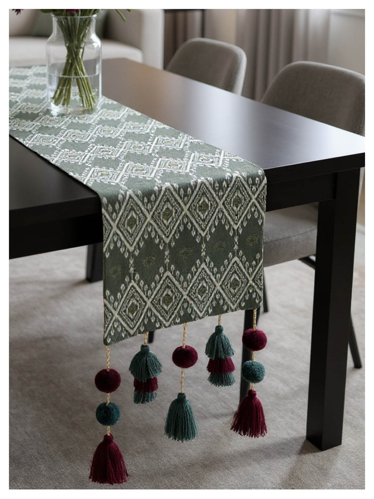 Grey Table runner with geometric pattern and tassels on a dining table