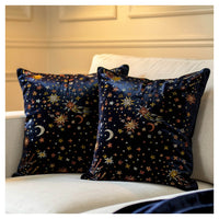 Two decorative pillows with celestial patterns on a white couch.