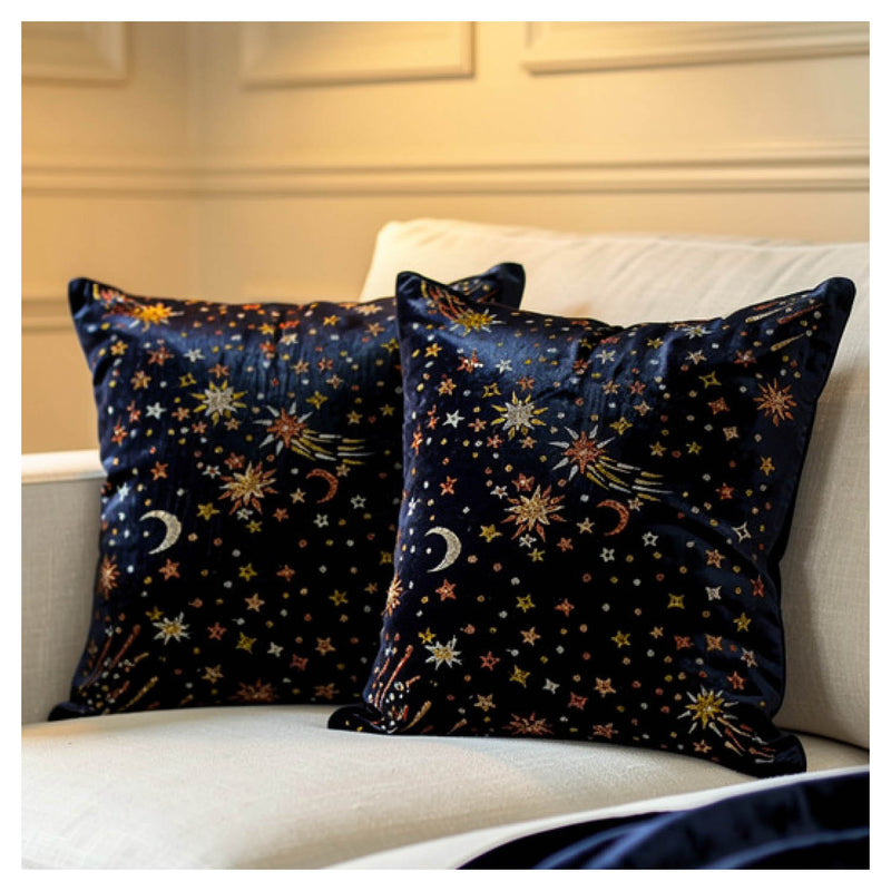 Two decorative pillows with celestial patterns on a white couch.
