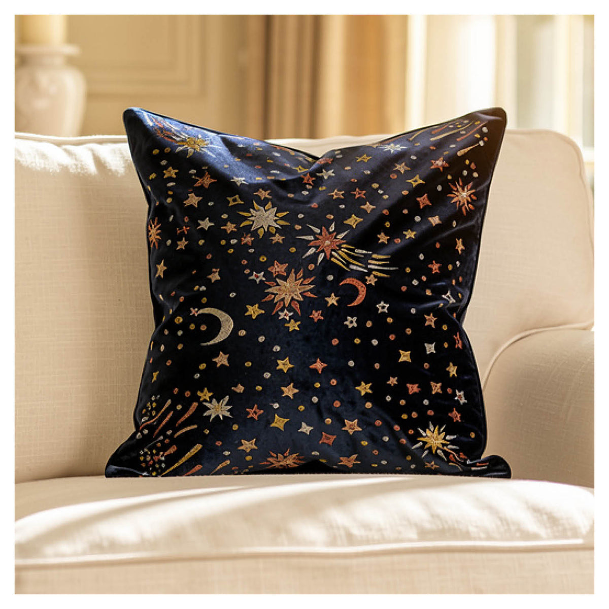 Blue starburst square cushion with gold, rose gold and champagne metallic embroidery styled on a beige couch