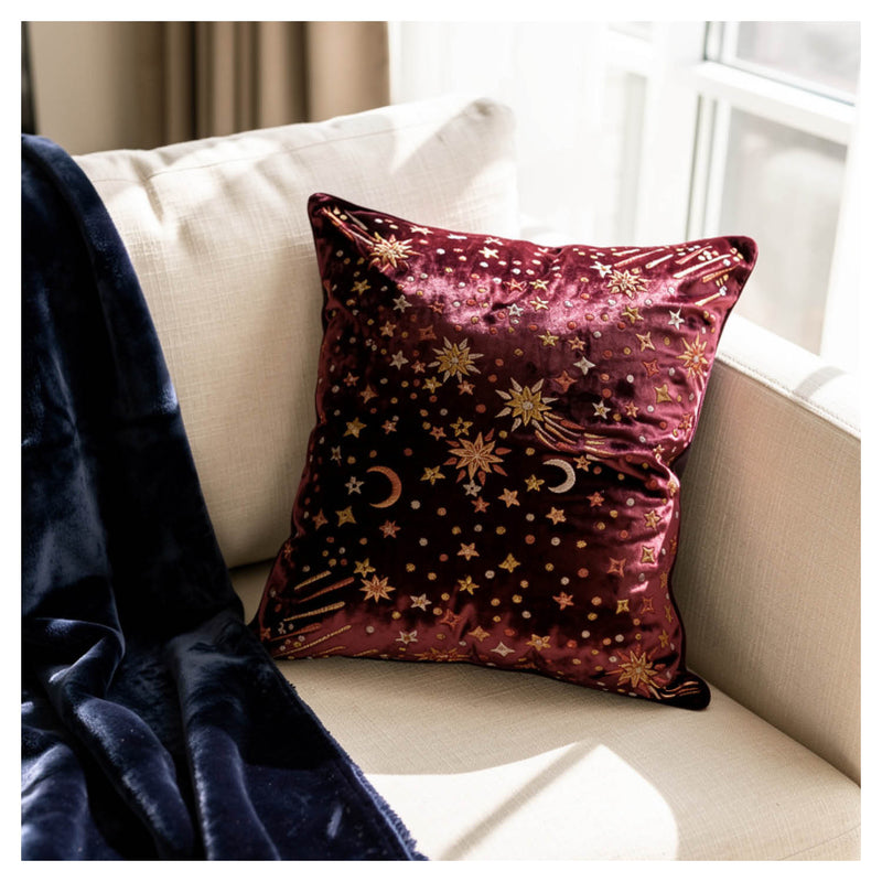 Decorative pillow in Crimson red with star and moon pattern on a beige couch