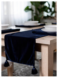 Midnight blue velvet table runner with matching tassels styled on a dining table