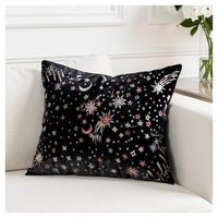 Black starburst square cushion with gold, rose gold and champagne metallic embroidery styled on a white couch