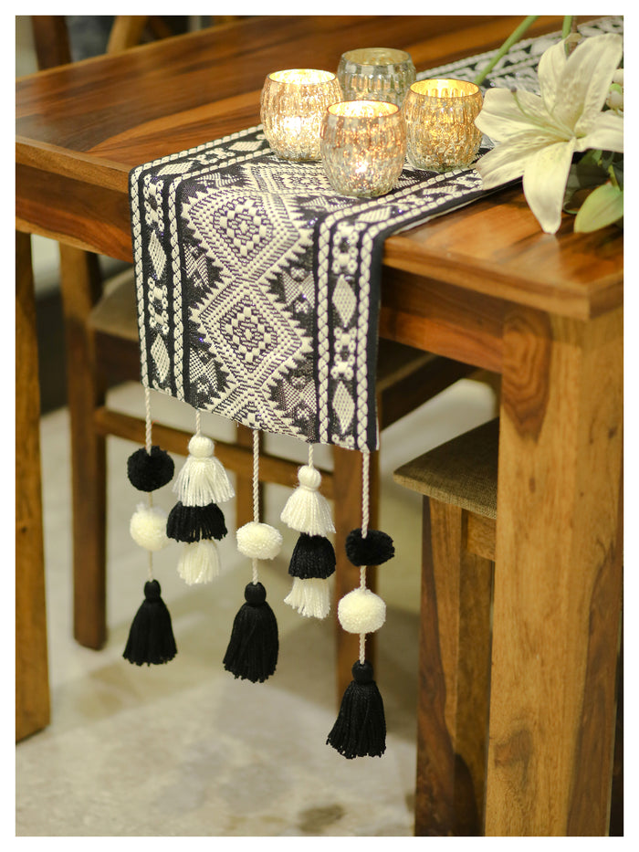 Black Aztec tasseled table runner styled on a dining table with monochrome décor